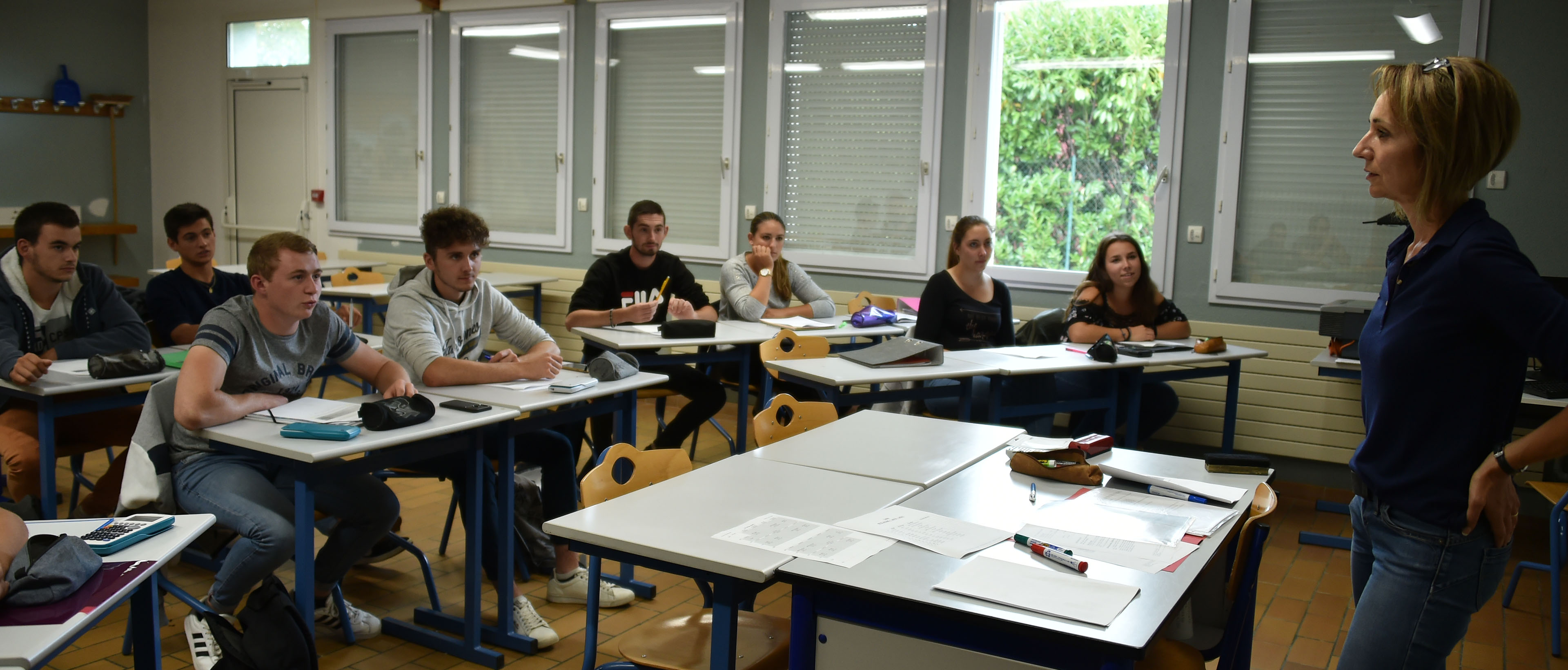 Elèves en salle de classe face à un professeur