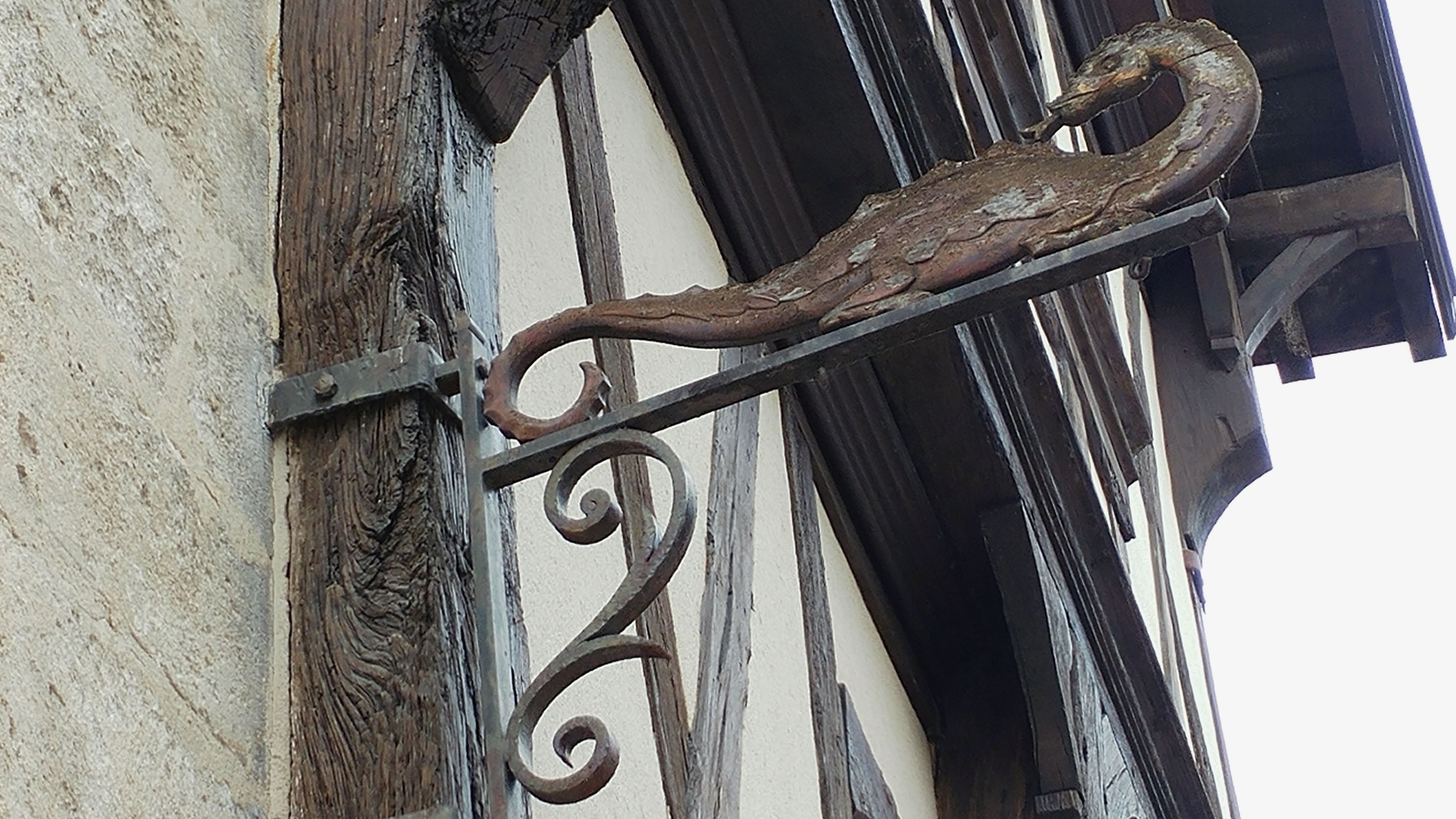 Enseigne en fer forgé représentant un salamandre, dans une rue de Cognac, en Charente