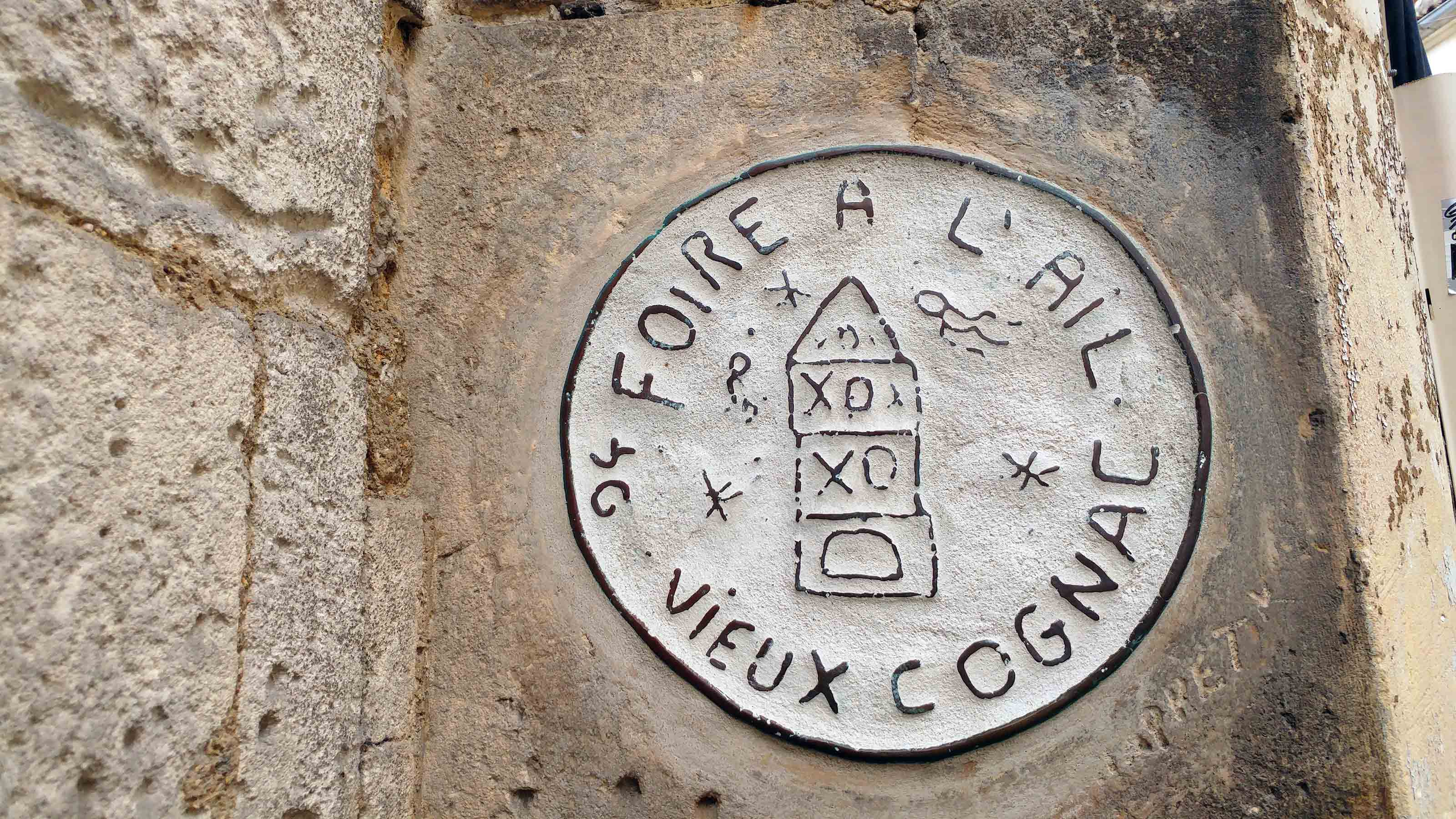 Un médaillon portant l'inscription "foire à l'ail" est scellé dans un mur du vieux Cognac, en Charente