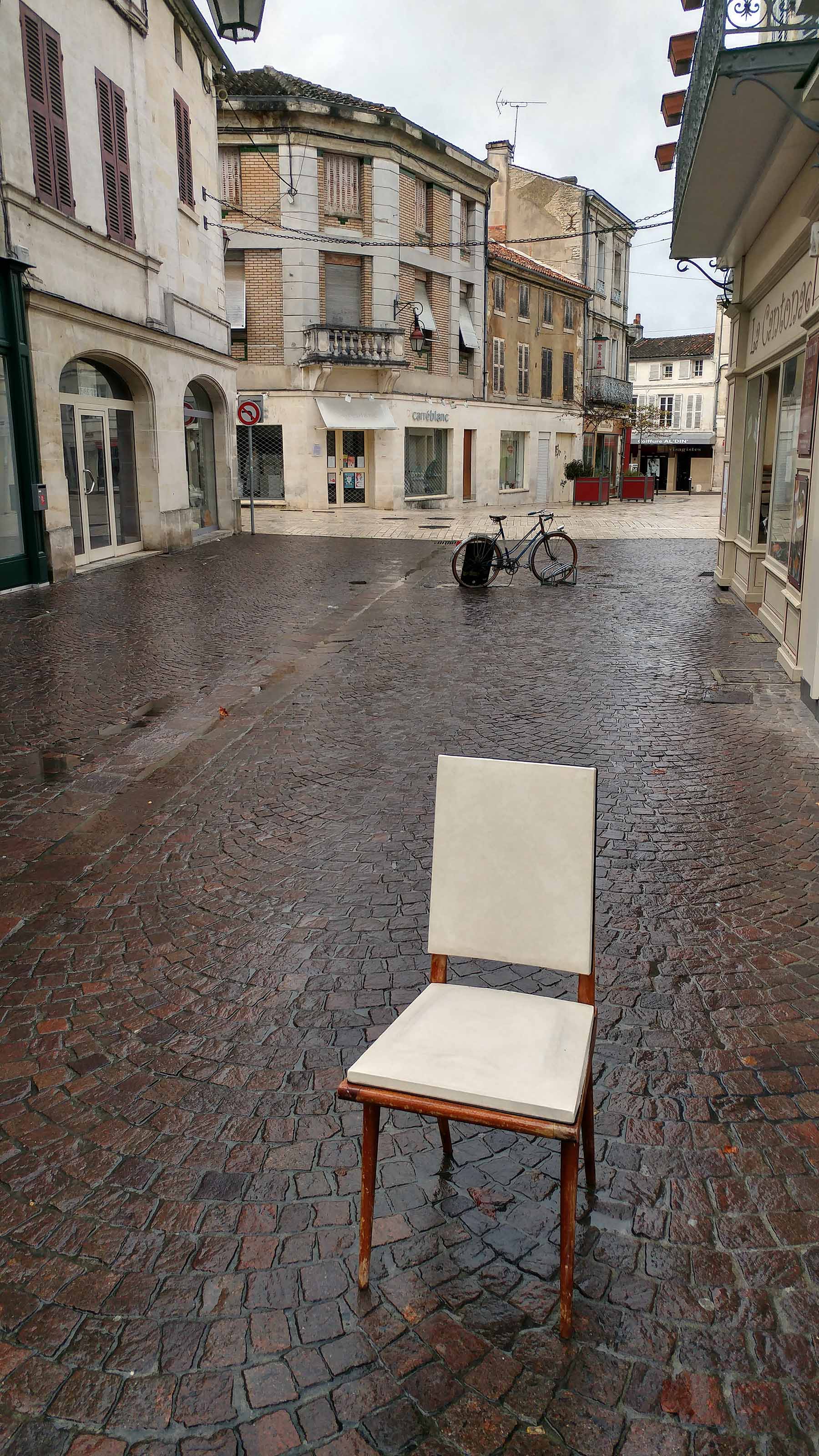 Vue insolite d'une chaise laissée vide dans une rue pluvieuse de Cognac, en Charente.