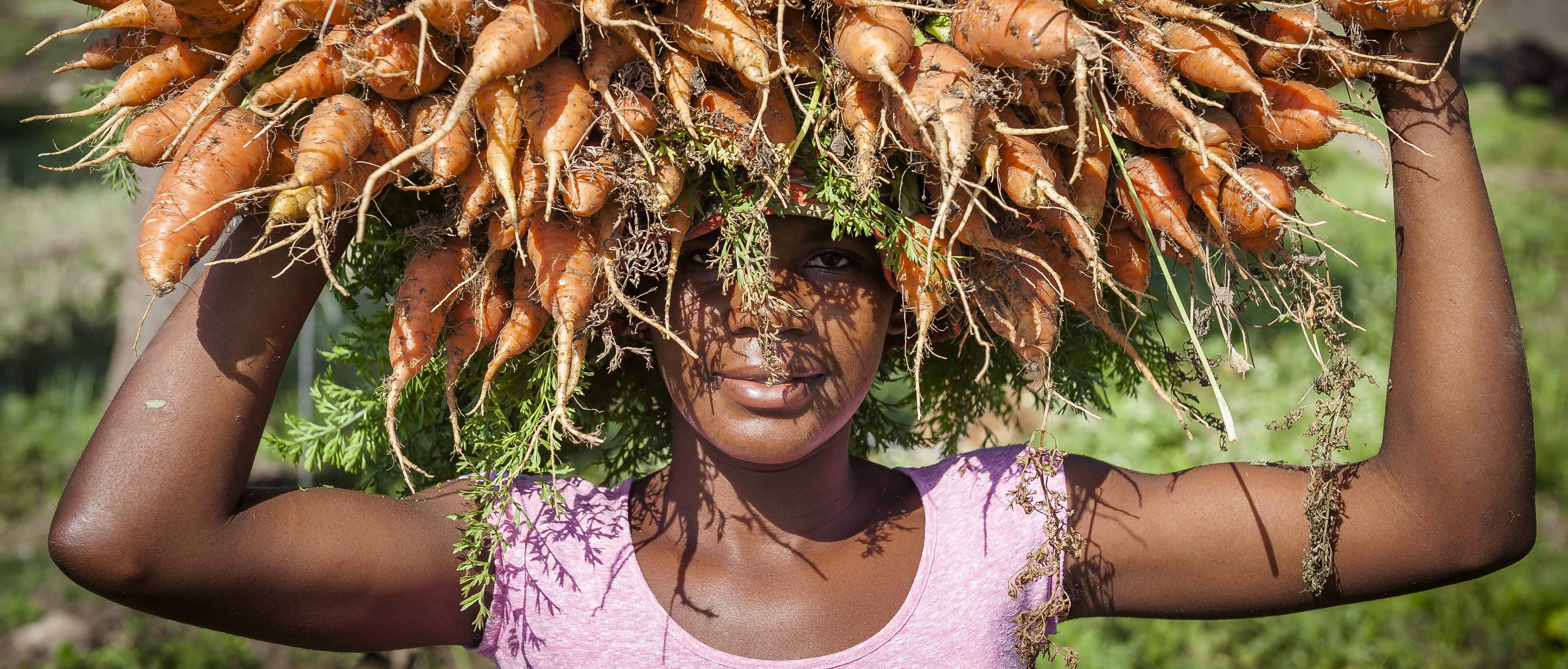 Cultivatrice à Haïti qui se prépare à aller vendre ses produits au marché après avoir retiré la part des voisins et rempli le grenier pour la consommation de la famille. Une photographie de Johson Sabin exposée en Nouvelle-Aquitaine, lors de l'exposition "Haïti, un autre regard", en juin 2021 à Bordeaux.