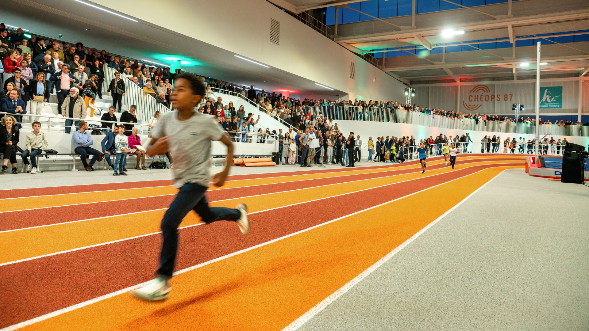 enfant courant sur la piste du stade