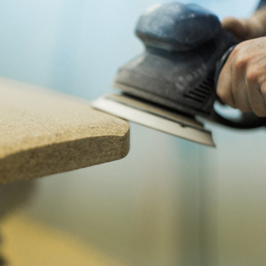 Ponçage d'une planche de surf en liège dans l'atelier de Notox, entreprise d'Anglet spécialisée dans les planches de surf écologiques.