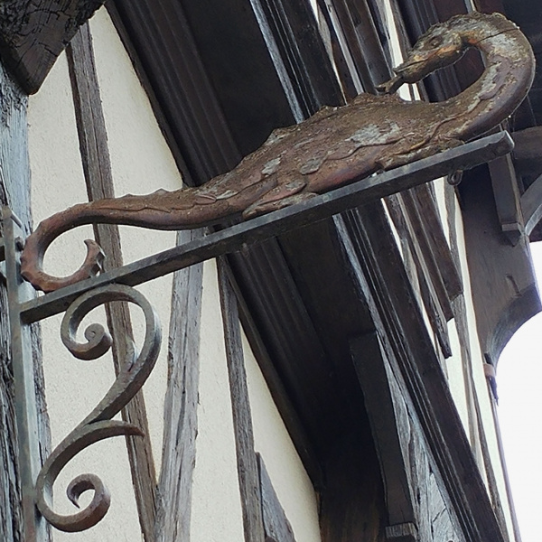 Enseigne en fer forgé représentant un salamandre, dans une rue de Cognac, en Charente