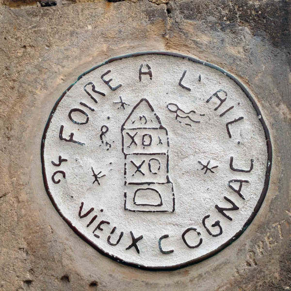 Un médaillon portant l'inscription "foire à l'ail" est scellé dans un mur du vieux Cognac, en Charente
