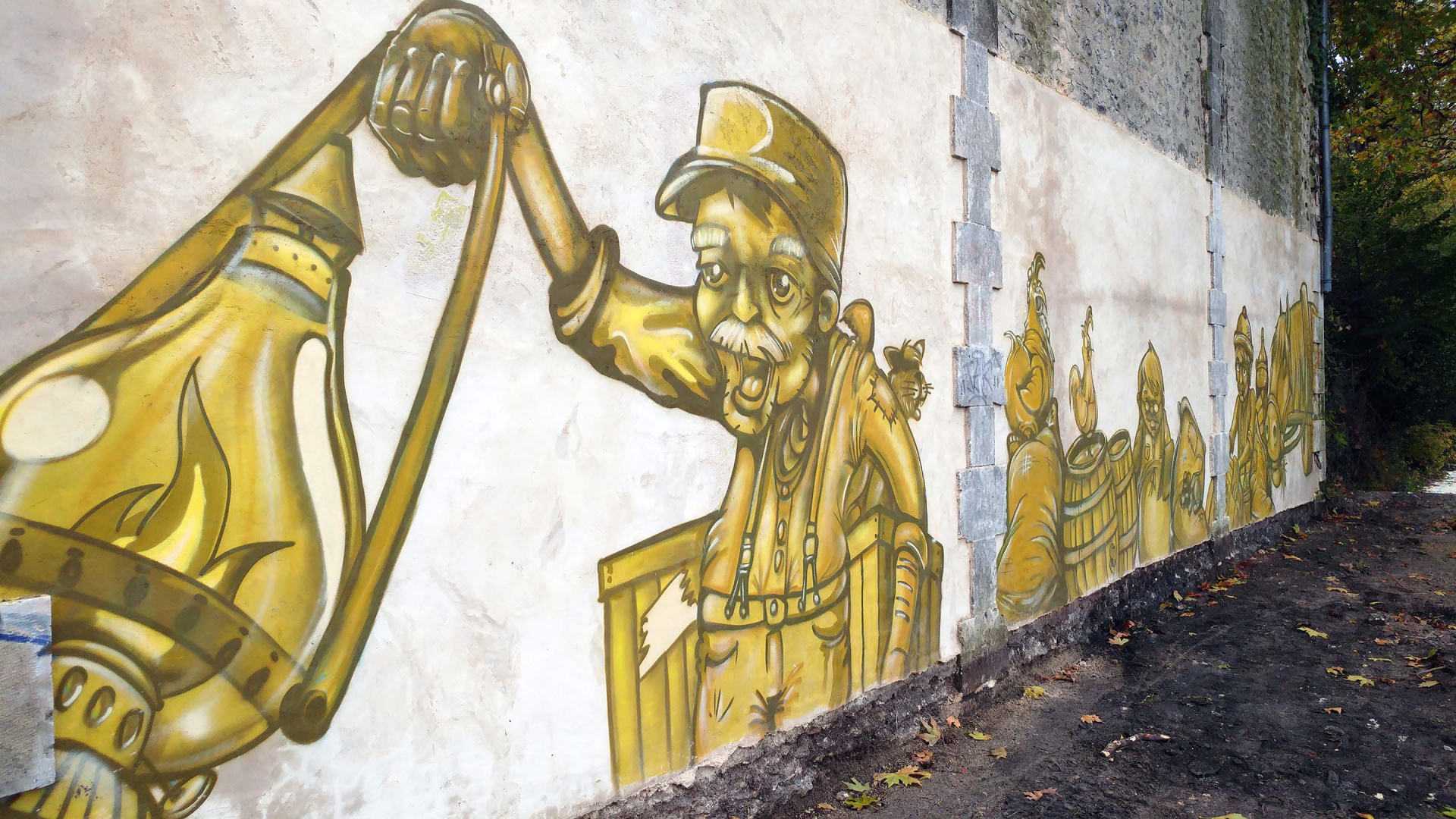Fresque peinte en jaune représentant un vieil homme avec une lanterne sur un mur de Cognac