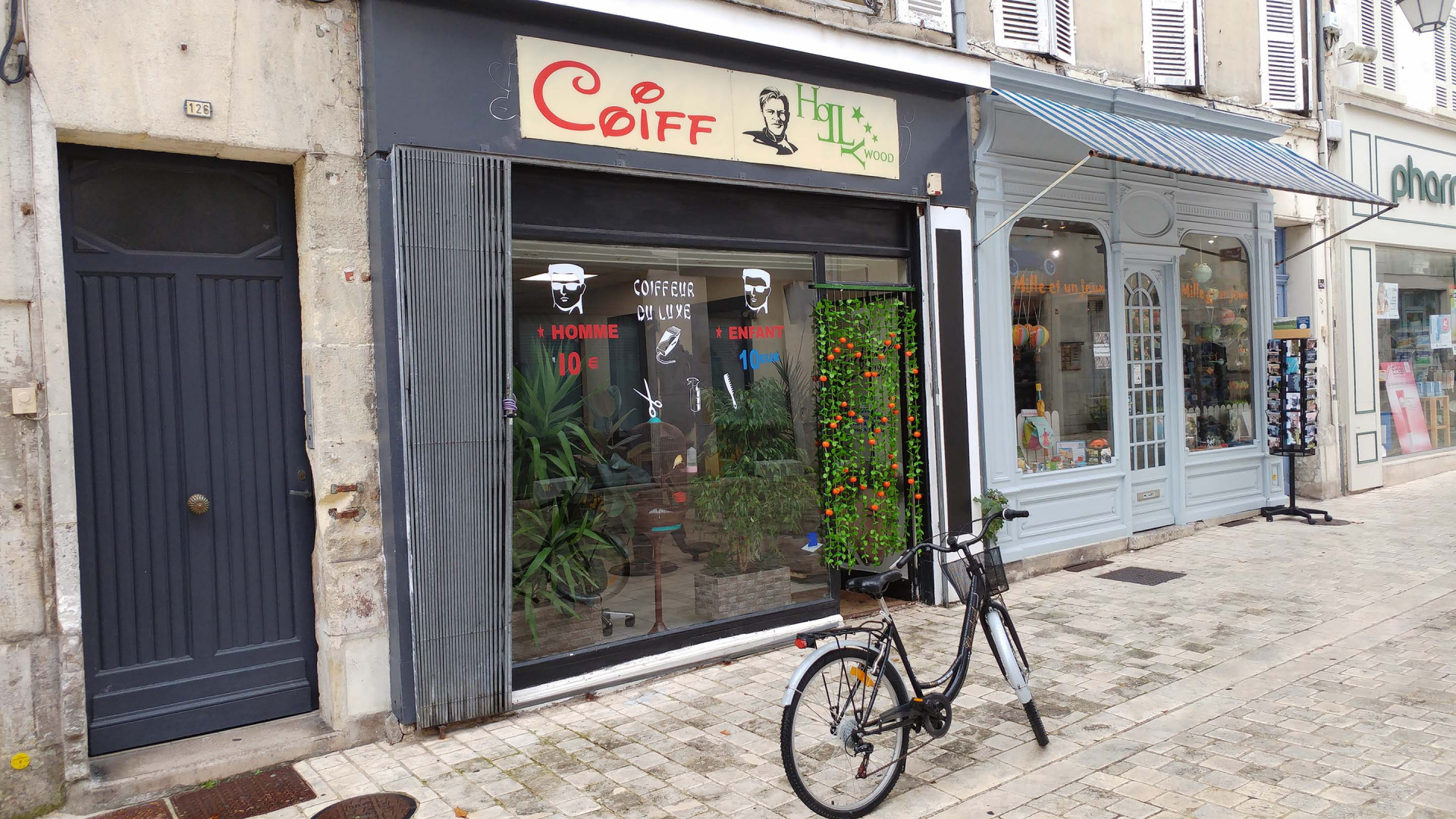 Le coiffeur du dimanche, avec un vélo devant sa boutique dans une rue de Cognac